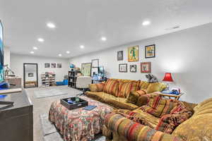 Carpeted living room with a textured ceiling