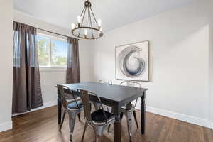 Dining room featuring dark hardwood / wood-style flooring and a notable chandelier