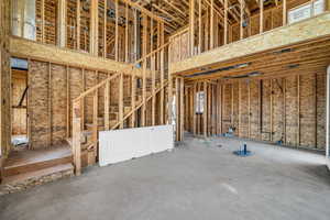 Miscellaneous room with concrete flooring and a towering ceiling