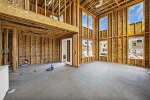 Misc room featuring concrete floors and a high ceiling