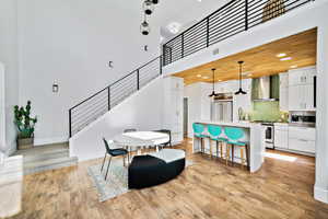 Dining area with a towering ceiling, light wood-type flooring, and sink