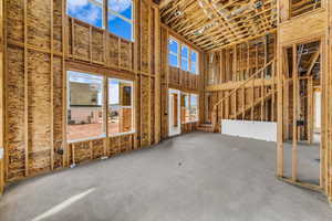 Misc room with plenty of natural light, a towering ceiling, and concrete floors