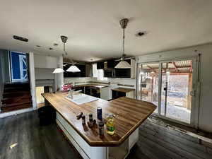 Kitchen featuring wooden counters, dark hardwood / wood-style flooring, backsplash, and sink