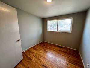 Empty room featuring hardwood / wood-style flooring