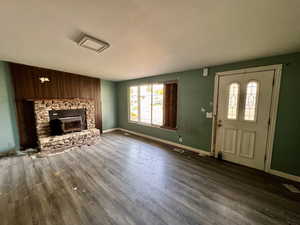 Foyer featuring wood-type flooring and a wood stove