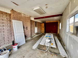 Miscellaneous room featuring concrete floors and brick wall