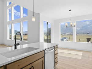 Kitchen featuring dishwasher, pendant lighting, plenty of natural light, and sink