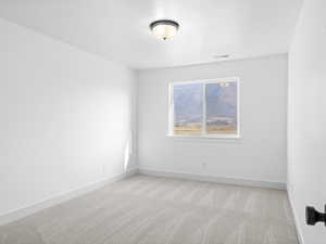 Unfurnished room with light carpet and a textured ceiling