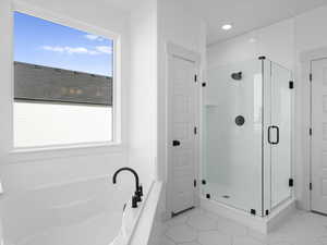 Bathroom with tile patterned floors and independent shower and bath