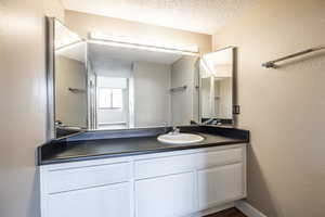 Bathroom featuring vanity and a textured ceiling