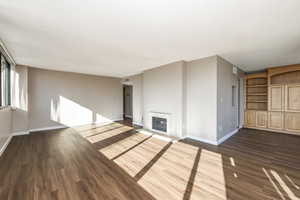 Unfurnished living room with a textured ceiling and dark hardwood / wood-style floors