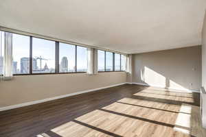 Unfurnished room featuring dark wood-type flooring and a textured ceiling