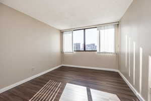 Spare room featuring a textured ceiling and dark hardwood / wood-style floors