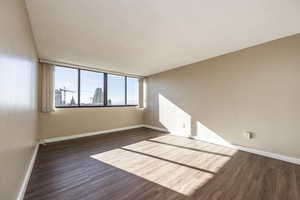 Spare room featuring a textured ceiling and dark wood-type flooring