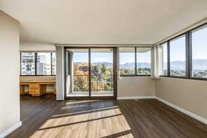 Spare room with a mountain view, a textured ceiling, dark hardwood / wood-style flooring, and built in desk