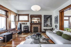 Living room with a fireplace and light hardwood / wood-style flooring