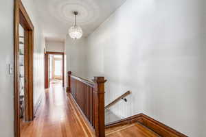 Hall featuring an inviting chandelier and light wood-type flooring