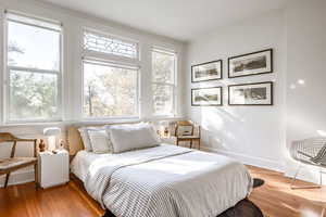 Bedroom with light wood-type flooring and multiple windows