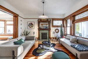 Living room with hardwood / wood-style floors and a tile fireplace