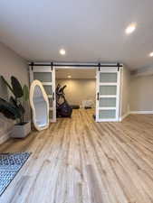 Workout room featuring a textured ceiling, a barn door. Can be used as a bedroom.