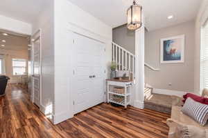 Foyer with dark hardwood / wood-style floors and crown molding