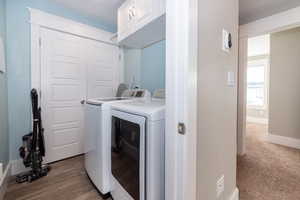 Laundry room featuring cabinets, independent washer and dryer, and wood-type flooring