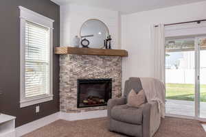 Living area with a fireplace and light carpet