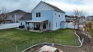 Rear view of house with a patio and a lawn