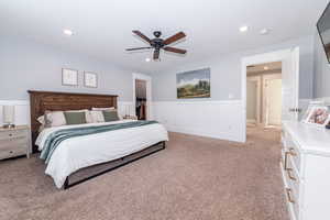 Carpeted bedroom with ceiling fan, a walk in closet, and a closet