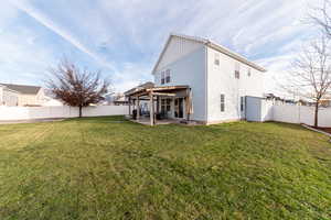 Back of house featuring a patio area and a lawn