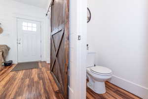 Foyer entrance with a barn door and dark hardwood / wood-style floors