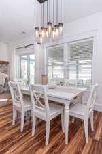 Dining area with hardwood / wood-style flooring and an inviting chandelier