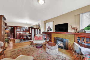 Living room with hardwood / wood-style flooring, a notable chandelier, and a fireplace