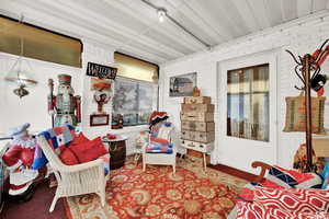 Sitting room featuring carpet floors and brick wall