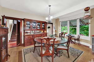 Dining area with light hardwood / wood-style flooring and an inviting chandelier