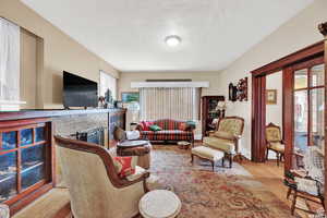 Living room with light hardwood / wood-style floors and a brick fireplace