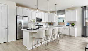 Kitchen with pendant lighting, white cabinetry, a kitchen island with sink, and appliances with stainless steel finiUnder Construction. Pictures of a model for example only. Colors and other features may vary from picture.