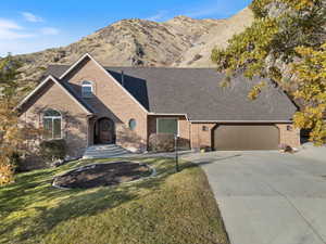 View of front facade featuring a mountain view, a garage, and a front yard