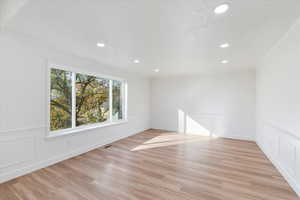 Unfurnished room featuring light wood-type flooring and ornamental molding