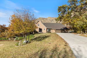 View of front of house with a mountain view, a garage, and a front yard