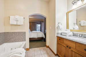 Bathroom with tile patterned flooring, vanity, and a washtub