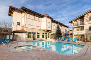 View of swimming pool with a patio area and a community hot tub