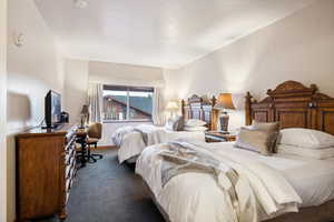 Bedroom with a textured ceiling and dark carpet