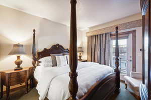 Bedroom with dark colored carpet and access to exterior