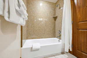 Bathroom featuring tile patterned flooring and shower / tub combo with curtain