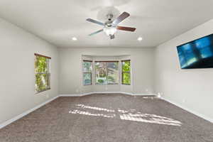 Carpeted spare room with ceiling fan