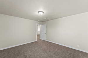 Unfurnished room with carpet floors and a textured ceiling