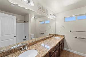 Full bathroom featuring toilet, plenty of natural light, vanity, and tile patterned flooring