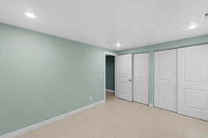 Unfurnished bedroom with a textured ceiling and two closets