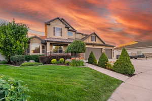 Craftsman-style home featuring a lawn, a garage, and covered porch